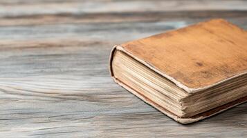 An old book sitting on a wooden table photo