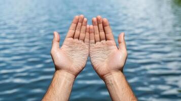 Hands with white spots on them in front of a lake photo