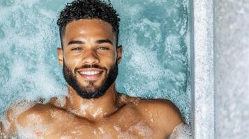 A man with a beard and a smile in a hot tub photo
