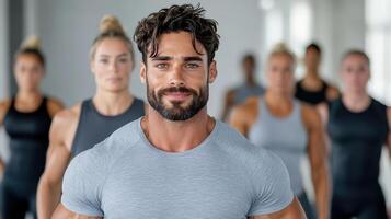 A man with a beard and a shirt is standing in front of a group of people photo