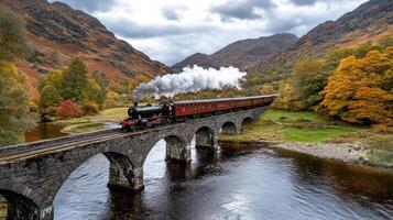 steam train crosses old stone bridge over deep river, surrounded by autumn trees photo