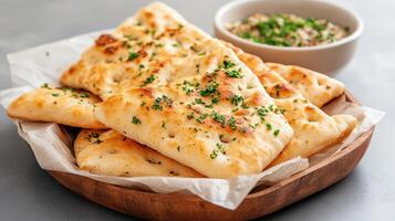 A bowl of bread with herbs and a plate of bread photo