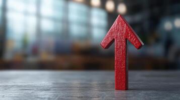 A red arrow pointing up on a wooden table photo