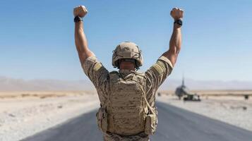 A soldier with his arms raised in the air on a road photo
