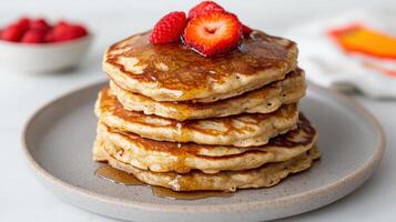 A stack of pancakes with syrup and strawberries photo