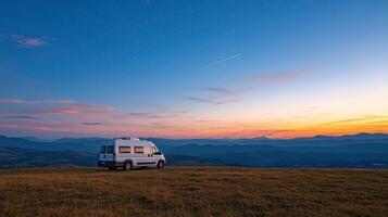A camper van is parked on a hill at sunset photo
