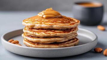 A stack of pancakes with peanut butter and almonds photo
