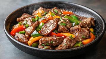 A bowl of beef and peppers with a steaming pot photo