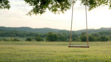 swing hanging from large oak tree in serene landscape, inviting relaxation and joy photo