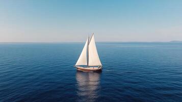 Sailing boat gliding smoothly over calm blue waters under clear sky photo