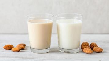 Two glasses of milk and almond milk on a wooden table photo