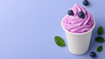 A cup of purple yogurt with blueberries on top photo