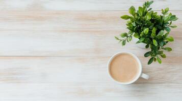 cozy scene featuring cup of coffee beside small potted plant on wooden table photo