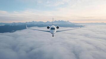 Aerial view of sleek aircraft flying above fluffy clouds with majestic mountains in background photo