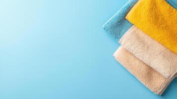 Soft towels in vibrant colors arranged neatly on blue background, perfect for relaxation photo