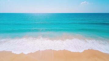 Calm turquoise beach with gentle waves lapping at shore under bright sunlight photo