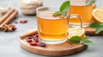 Warm herbal tea with citrus and dried fruits garnished with fresh leaves photo