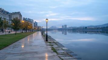 serene riverside view with reflections water, streetlights illuminating path, and calm photo