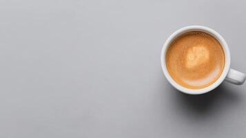 close up of creamy espresso in white cup on smooth gray surface, evoking warmth and comfort photo