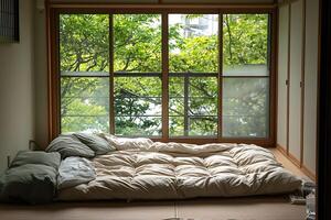 A bed with a blanket on it sitting in front of a window photo