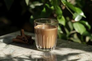A glass of coffee with cinnamon and a cinnamon stick photo