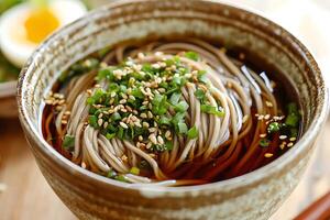 A bowl of noodles with a spoon and chopsticks photo