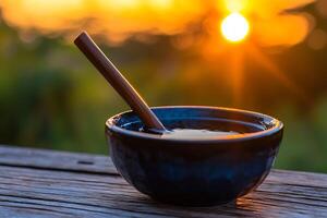 A bowl of water with a wooden spoon sitting on a table photo