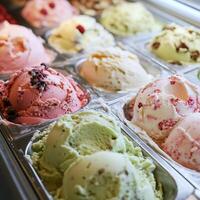 Delicious Assortment of Ice Cream Flavors in Display Case. A close-up shot showcasing various creamy ice cream scoops in metallic containers. photo