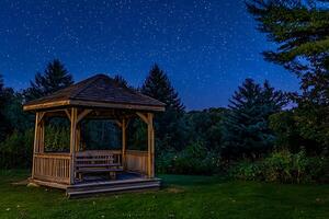 Serene Night Scene Gazebo Under a Starlit Sky. A peaceful wooden gazebo sits invitingly under a breathtaking night sky filled with countless stars. photo