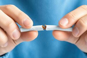 Determined individual breaking a cigarette in half as a symbol of commitment to quitting smoking and choosing a healthier lifestyle photo