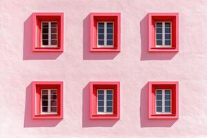 Contemporary blush wall featuring red window frames in minimalist architectural design showcasing color-block aesthetics photo