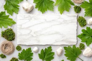 Natural elements arranged on a calm, neutral background featuring green leaves, moss, textured paper, twine, and wooden pieces photo