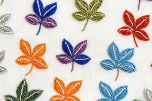 Colorful beaded floral patches arranged on linen fabric create an inspiring flatlay for textile design and craft projects photo