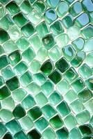 Glossy green tiles creating textured background surface photo