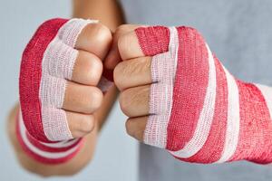Boxer wrapping hands with red and white boxing bandages photo