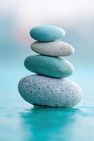 Stacked stones on a tranquil surface create a calming focal point at a serene lakeside at sunset photo