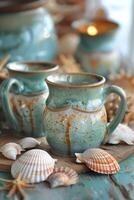 Ceramic Mugs and Seashells on Wooden Table photo