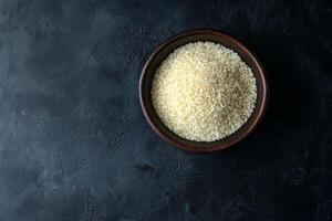 Bowl of white rice on a black background, top view. photo