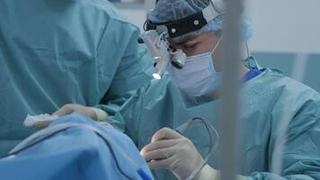 Operation of removing tonsils. tonsillectomy under deep anesthesia, using latest devices, cold plasma method, cuts swelling in throat, doctor works with new probe, medical headlamp, surgical loupes 4 video