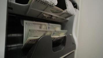 Close-up of a money counting machine processing US dollar banknotes. Represents financial transactions, currency handling, banking, and cash management in a business context 2 video