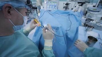 Operation of removing tonsils. tonsillectomy under deep anesthesia, using latest devices, cold plasma method, cuts swelling in throat, doctor works with new probe, medical headlamp, surgical loupes video