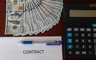 estate agent with customer after contract signature of buying house for more money, US Dollar banknotes money on printed contract paper and pen to sign photo