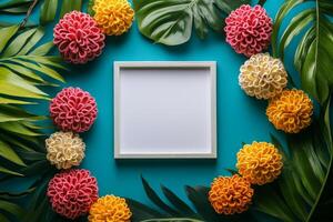 A blank frame surrounded by colorful flowers and leaves on a turquoise background. photo