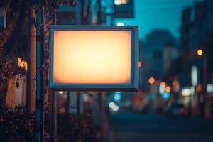A blank illuminated sign in a dimly lit street, suggesting a business or advertisement space. photo