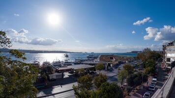 A breathtaking panoramic view of the Bosphorus Strait, featuring a vibrant harbor filled with boats and ferries. The sun shines brightly in the clear blue sky, casting a shimmering reflection. photo