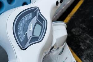 Bangkok, Thailand - March 27, 2025 Dashboard is on a white vespa LX 125 for shows the speed and amount of gasoline in the tank. photo