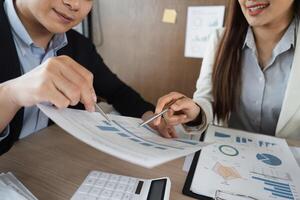 Business Analysis and Collaboration. Two professionals discussing financial reports to enhance decision-making in a corporate environment. photo