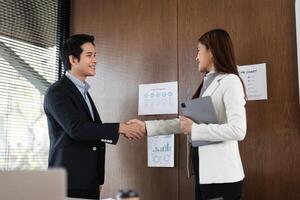 Handshake and Agreement. Two business professionals sealing a deal with a firm handshake in a modern office. photo