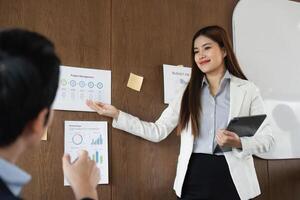 Engagement and Professionalism. A confident businesswoman presents key project metrics while engaging with her audience. photo