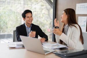 Building Relationships and Enjoying Coffee. Two colleagues share a moment of laughter and coffee in the office. photo